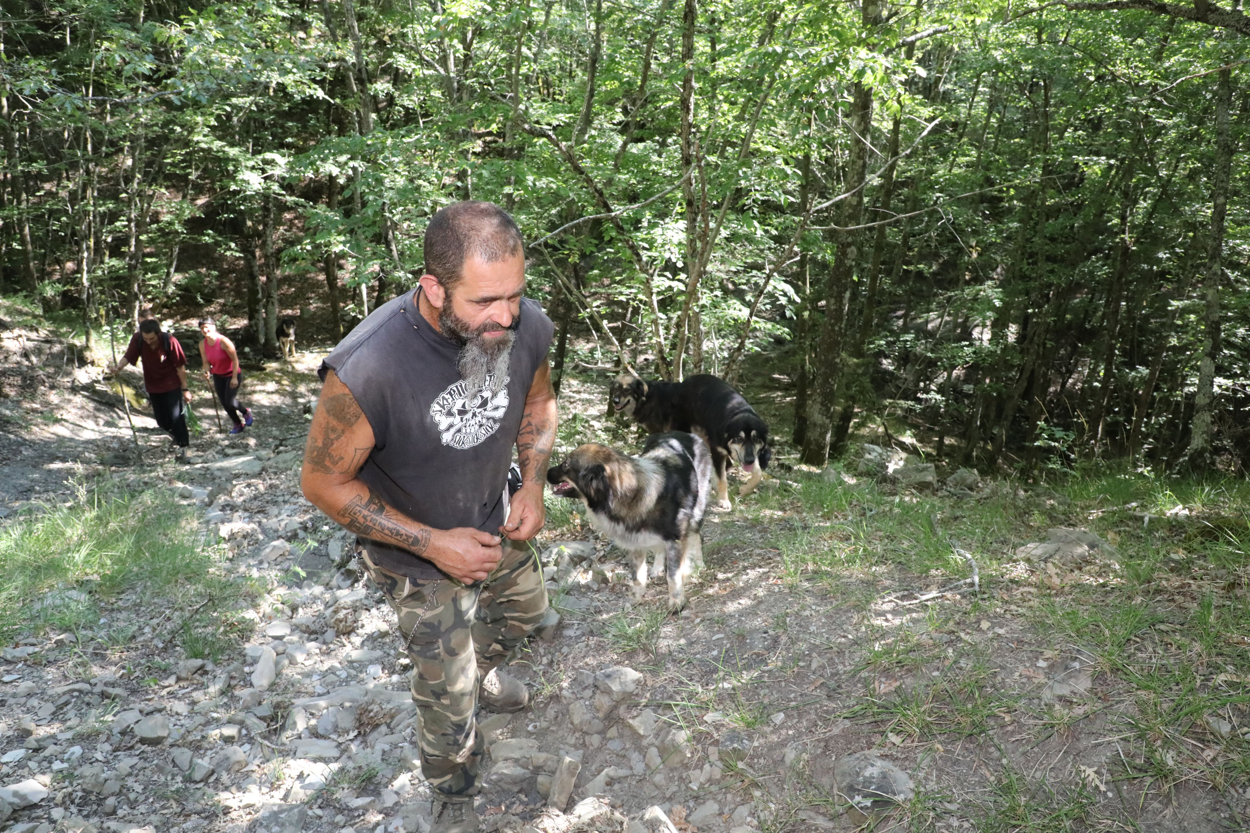 Kathrin et Cristian accompagnent dans les sous-bois leurs "pastore della Sila", chiens au pelage noir chamarré de blanc. / Eric Camoin